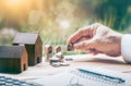 House placed on coins Men`s hand is planning savings money of coins to buy a home. Royalty Free Stock Photo