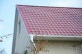 House with plaster walls, red metal roof and white plastic rain Royalty Free Stock Photo