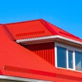 House with plastic windows and a red roof of corrugated sheet Royalty Free Stock Photo