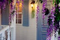 House porch with a lantern, blue door and window and wisteria flowers decoration Royalty Free Stock Photo