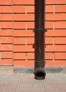 House rain gutter downspout with wall holder without water drainage on the pavement Royalty Free Stock Photo
