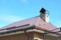 House rain gutter system and roof protection from snow board Snow guard on residential house roofing construction with chimney.