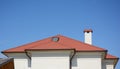 House red clay roof with attic skylight, chimney, roof gutter and copy space. Royalty Free Stock Photo