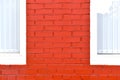 A house with a red painted brick wall and white Windows Royalty Free Stock Photo