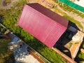 A house with a red roof made of corrugated metal sheets. Roof from corrugated metal profile. Metal tiles. Royalty Free Stock Photo