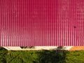 A house with a red roof made of corrugated metal sheets. Roof from corrugated metal profile. Metal tiles. Royalty Free Stock Photo