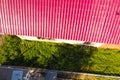 A house with a red roof made of corrugated metal sheets. Roof from corrugated metal profile. Royalty Free Stock Photo