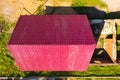 A house with a red roof made  metal sheets. Roof from corrugated metal profile. Metal tiles Royalty Free Stock Photo