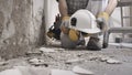 House renovation concept, construction worker holds in hands helmet and safety headphones, he wears the tool bag on his belt ,