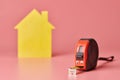 House renovation funny concept. Metal tape measure and other repair items. Home repair and redecorated concept. Yellow house