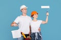 House Renovation Services. Happy Couple In Hardhats Holding Paint Roller And Bucket Royalty Free Stock Photo