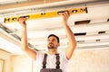 House renovation worker checking the alignment of a ceiling Royalty Free Stock Photo