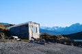 House on river with mountains at back. Royalty Free Stock Photo