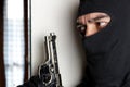 House robbery by man in a black hoodie and black mask and gun. Royalty Free Stock Photo