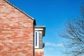 House roof gable end red brick over deep blue sky, Side of House from exterior with branches tree and Spring sky,Mordern English