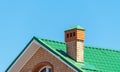 house with a roof from a green shingles with a pipe