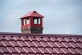 House roof with modern red metal tiles and chimney close up Royalty Free Stock Photo