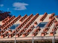 A house roof under construction, showing stacks of terracotta tiles ready for fitting on wooden battens. Royalty Free Stock Photo