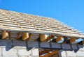 House roofing construction panorama. Installing wooden rafters, eaves, waterproofing logs with bitumen