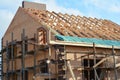 House rooftop wooden frame construction. Incomplete house rooftop roofing construction trusses, vapor barrier, wooden beams,