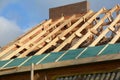 House rooftop wooden frame construction. Incomplete house rooftop roofing construction trusses, vapor barrier, wooden beams,