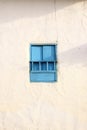 Blue simple, rural, and beautiful windows against a white rustic wall Royalty Free Stock Photo
