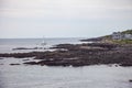 House and Sailboat near Oarweed Cove along the rocky coast of Maine in Ogunquit Royalty Free Stock Photo