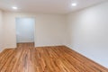 A house for sale with an empty white living room or den of a newly renovated and painted house with dark hardwood floors Royalty Free Stock Photo