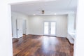 A house for sale with an empty white living room or den of a newly renovated and painted house with dark hardwood floors Royalty Free Stock Photo