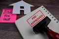 House For Sale write on a book and Red Handle Rubber Stamper Pre-Approved text isolated on the table