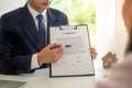 The house sales representative is showing the details of the contract or house purchase documents to the customers or the new land Royalty Free Stock Photo