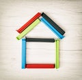 House shape of colorful bag clips on the wooden background Royalty Free Stock Photo