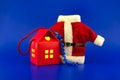 House shaped gift box and red Santa Claus suit Royalty Free Stock Photo