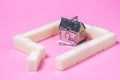 House-shaped tea strainer on a pink background. Tea strainer with sugar cubes. Refined sugar. Small house. Brewing tea.