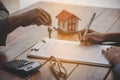 House signers signing signature loan document to home ownership with real estate agents ownership. Mortgage and real estate