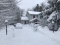 House during a snow storm cars in driveway