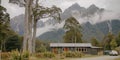 A house surrounded by trees, with distant mountains in the background Royalty Free Stock Photo