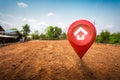 House symbol with location pin icon on empty dry cracked swamp reclamation soil in real estate sale or property investment concept