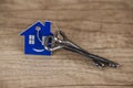 House symbol with silver keys on wood. Real estate concept Royalty Free Stock Photo