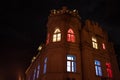House with a tower with lights on the windows in different colors. Day of proclamation of the Republic of Latvia