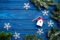 House toys and snowflakes to decorate christmas tree for new year celebration with fur tree branches on blue wooden Royalty Free Stock Photo