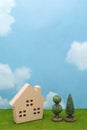House and trees on green grass over blue sky and clouds. Royalty Free Stock Photo