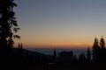 House and trees silhouettes on clear morning sky background. Village silhouette in mountains at dawn with copy space.