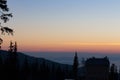 House and trees silhouettes on clear morning sky background. Village silhouette in mountains at dawn with copy space.