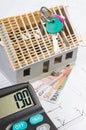 House under construction, keys, calculator and currencies euro on electrical drawings, concept of building home Royalty Free Stock Photo