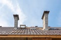 House under construction. Roofing tiles installation. New roof with skylight and chimneys.