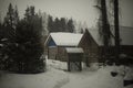 House in village in winter. Farming in forest in snow. Roof in snow. Small house