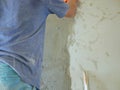 A house wall being plastered and getting close to a completion by a construction worker