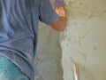 A house wall being plastered and getting close to a completion by a construction worker