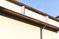 House wall with gutter and drainpipe on blue sky background Royalty Free Stock Photo